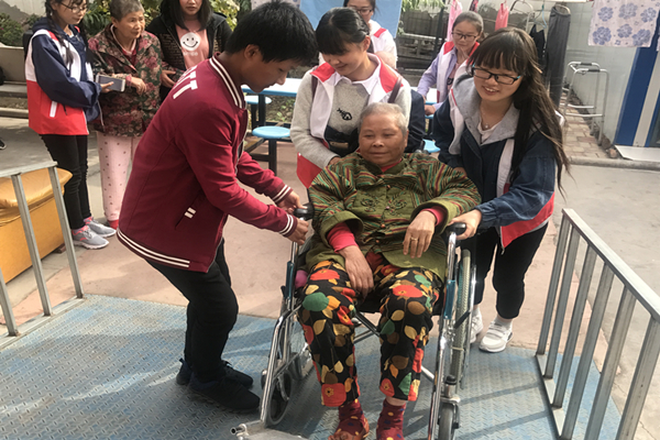 志愿者推老人进屋.jpg